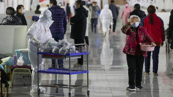 A nurse distributes medicine to patients at a temporary hospital situated in the Tazihu Gymnasium in Wuhan, China