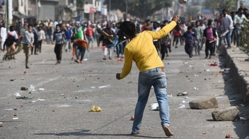 A protester hurls stones during clashes in New Delhi