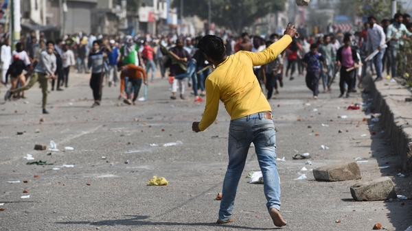 A protester hurls stones during clashes in New Delhi