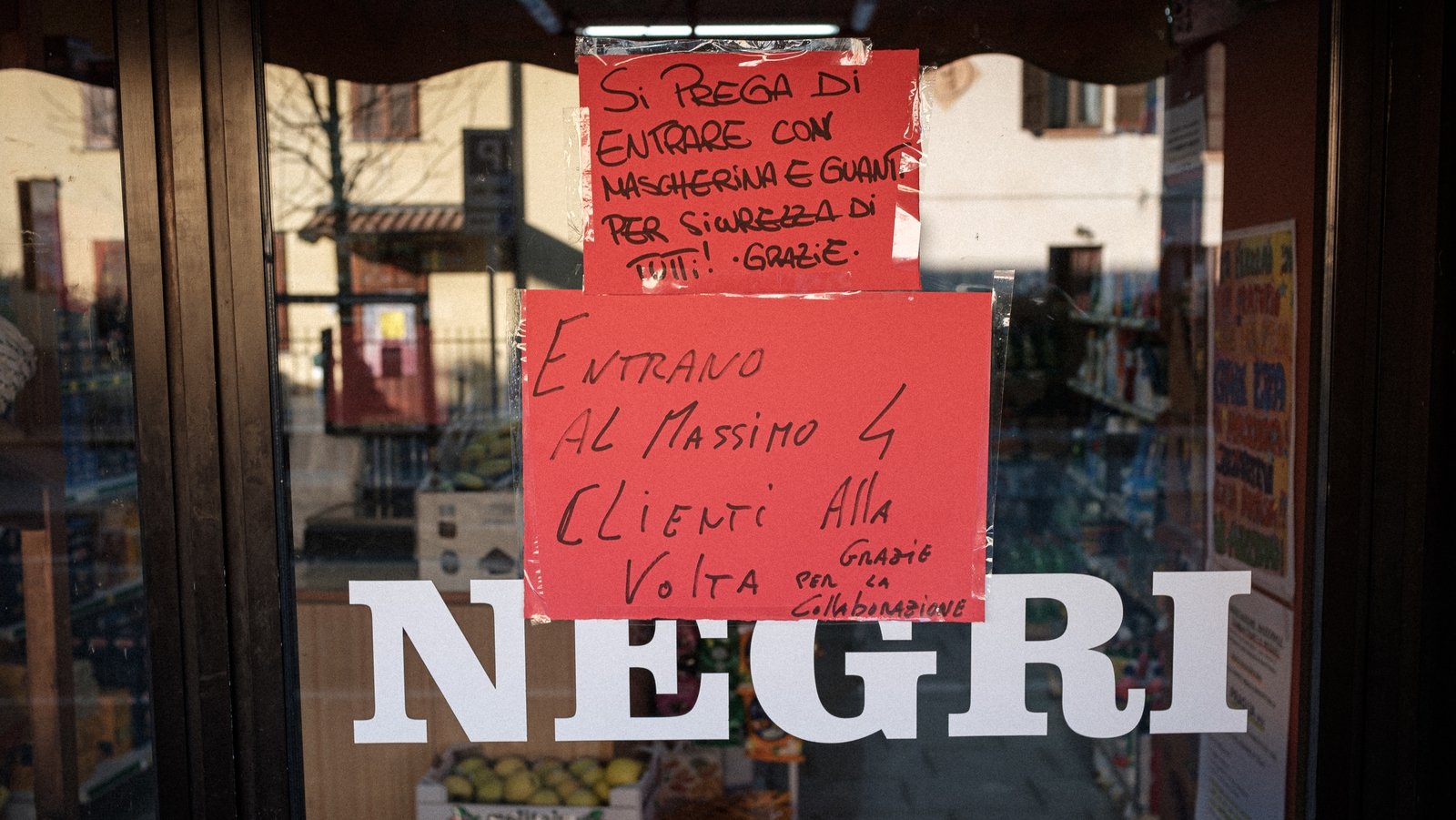 A sign reads: 'Please enter with mask and gloves for everyone's safety - four customers at a time'.