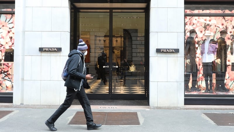 A man wears a protective mask while walking down a street in Milan today