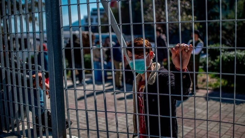 A migrant waits in the port of Lesbos in Greece