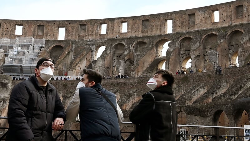Tourists wear face masks as they visit the Colosseum in Rome