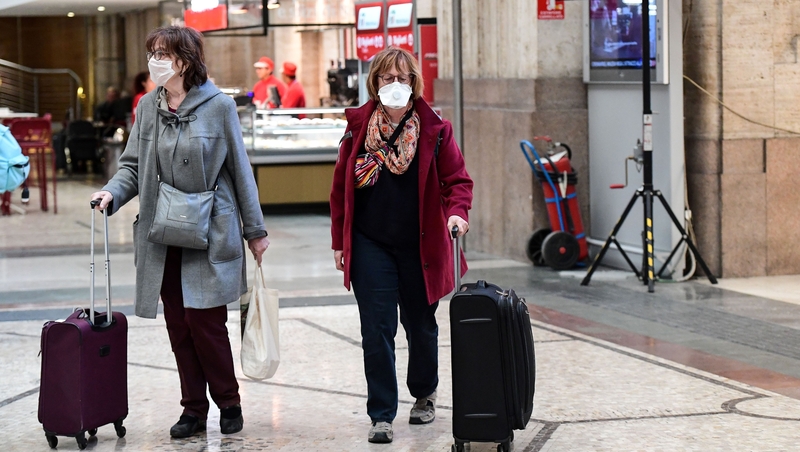 Passengers wearing protective face masks at Milano Centrale railway station