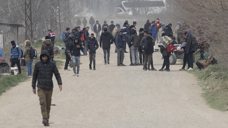Migrants and refugees carrying their belongings walk along the Turkish-Greek border, near the Pazarkule border gate in Turkey
