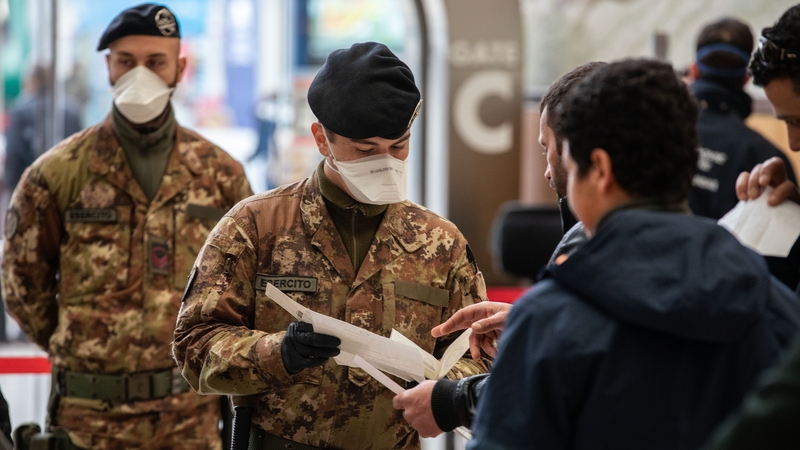 talian State Police officers and Italian soldiers process passengers leaving from Milano Centrale train station
