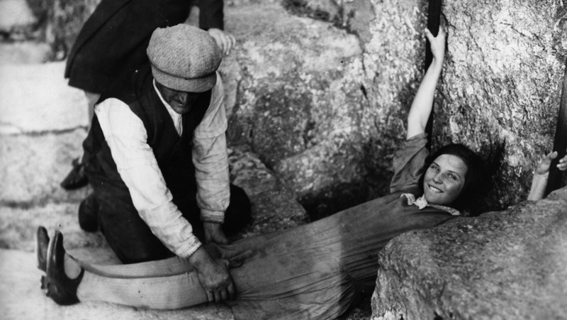 1930: A girl lies flat on the ground, in order to kiss the Blarney Stone in Blarney Castle, Cork city. Photo: Getty.