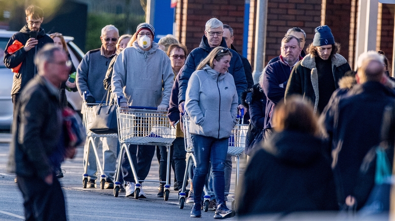 People queue outside a Tesco supermarket in Liverpool
