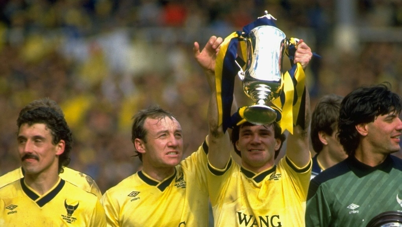 David Langan and Ray Houghton of Oxford United lift that year's League Cup trophy aloft