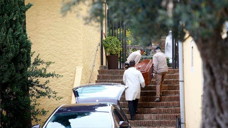 Mortuary workers carry a coffin outside a church in Barcelona