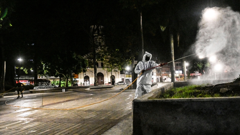 A police officer wearing protective clothing disinfects a park in Colombia