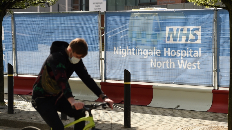 A man cycles by a sign for a new 'Nightingale' hospital in Manchester