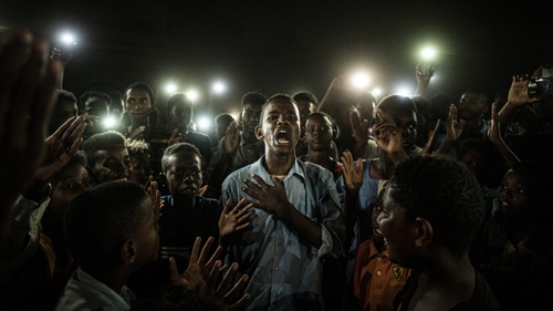 Yasuyoshi Chiba won the prize for his picture of a mobile-lit Sudanese demonstrator reciting protest poetry