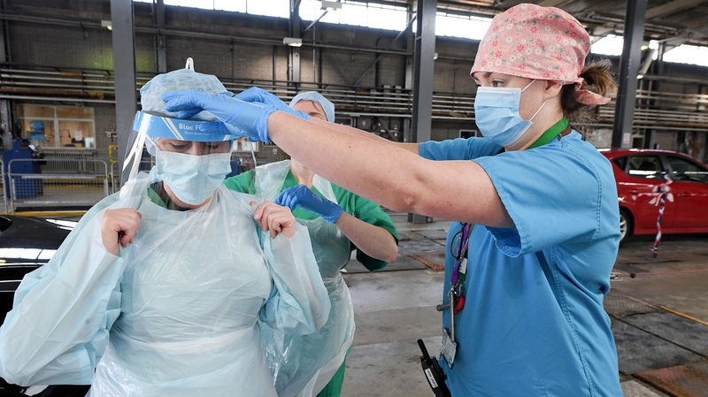 Medical staff put on PPE at a drive-through Covid-19 testing centre in Belfast
