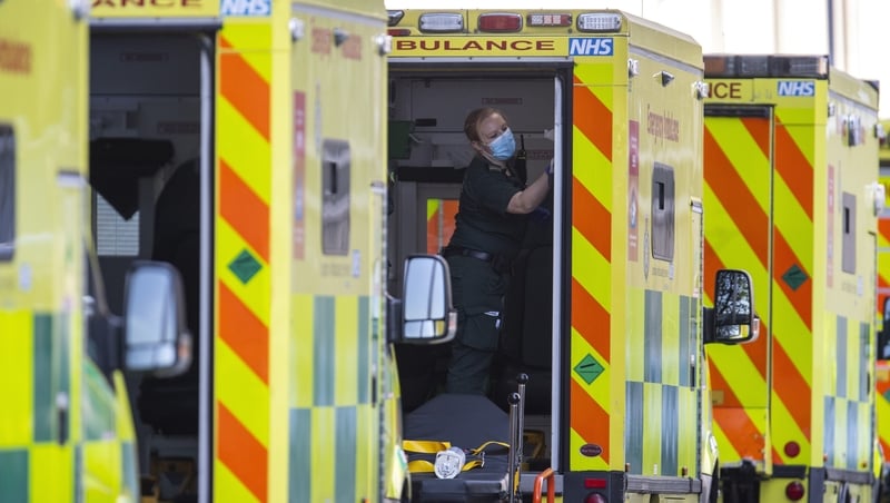 A London Ambulance worker cleans an ambulance outside of the Royal London Hospital in London