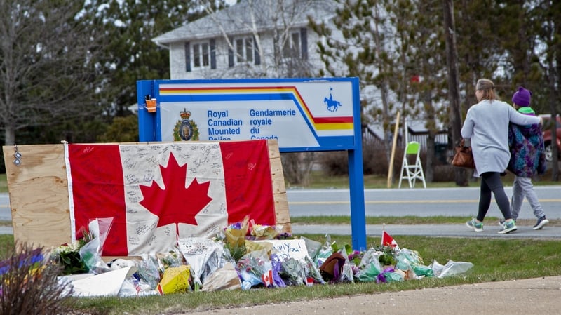 A woman comforts her daughter after they placed flowers at a memorial in Enfield, Nova Scotia