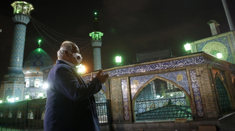An Iranian man wearing a face mask prays outside the Saleh Shrine in Tehran at the start of Ramadan. Photo: Getty Images