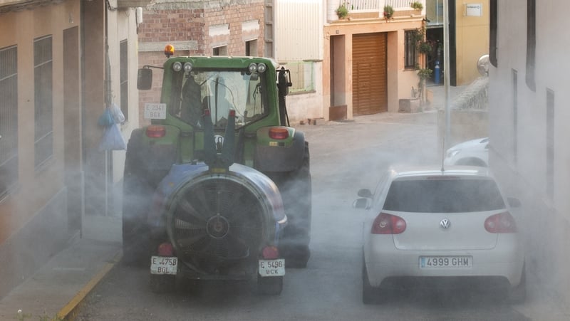 A volunteer farmer sprays disinfectant on the streets in rural Spain