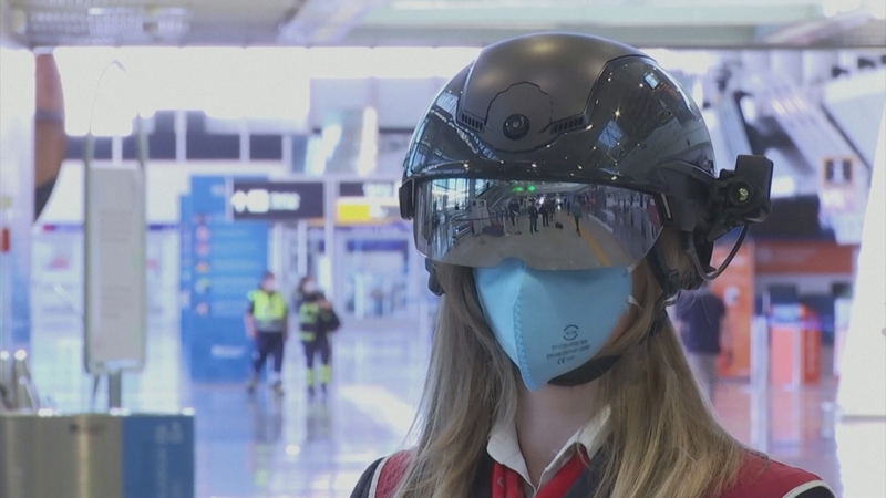 Airport staff wear the big black Robocop-style helmets along with masks, gloves and their uniforms