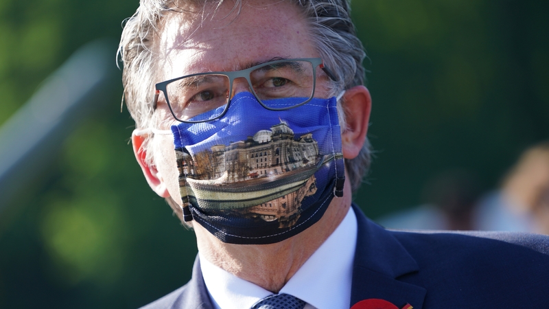 A man wears a facemask with a picture of the Reichstag on it at a VE Day ceremony in Berlin