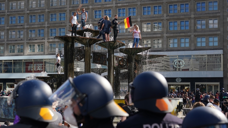 People stood on top of a fountain to protest against the lockdown measures in Berlin