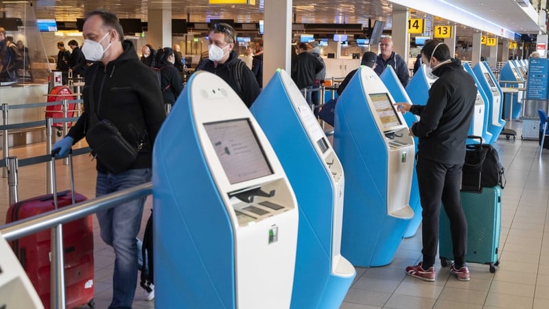 Travellers wearing face coverings at Amsterdam's Schiphol Airport in the Netherlands