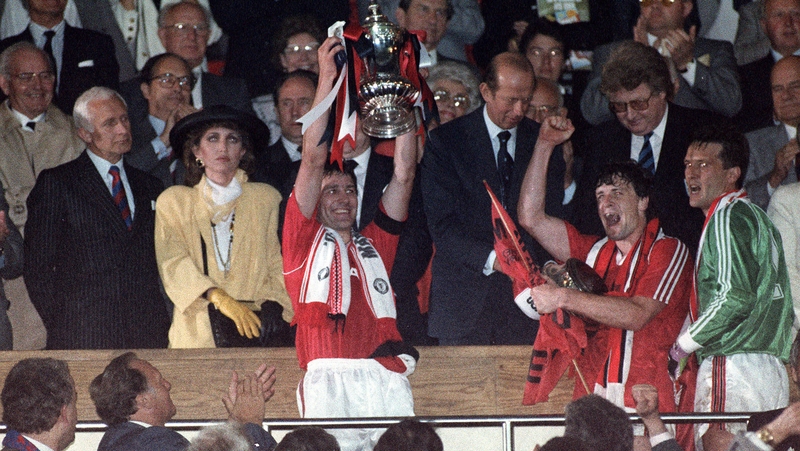 Manchester United captain Bryan Robson holds up the FA Cup in 1990