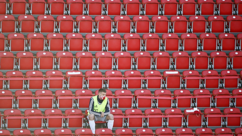 Bayern Munich substitute Lukas Mai in the stands wearing a protective face