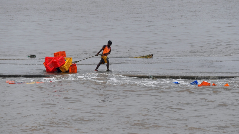 A fisherman pulls crates on a pier ahead of the cyclone at the Madh fishing village in the north western coast of Mumbai today