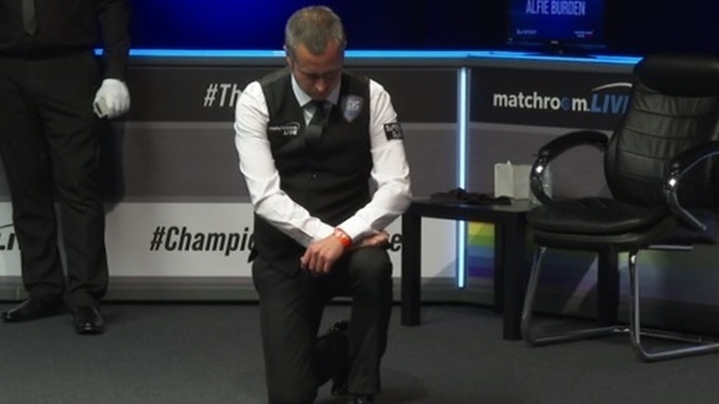 Alfie Burden takes a knee prior to the start of his Championship League match against Ryan Day