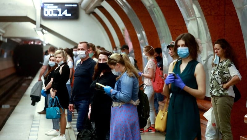 Commuters in face masks are seen at the Park Pobedy Station in Moscow