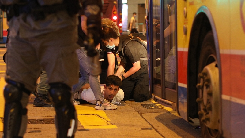 Police detain an activist during a rally to mark a year of pro-democracy rallies in Hong Kong