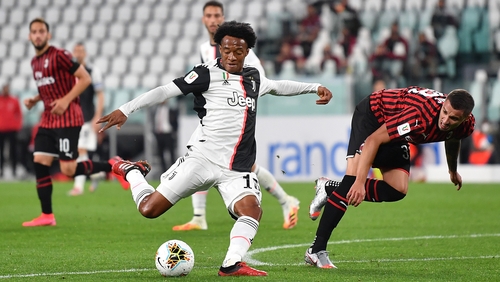 Juan Cuadrado (L) of Juventus in action against Rade Krunic of AC Milan