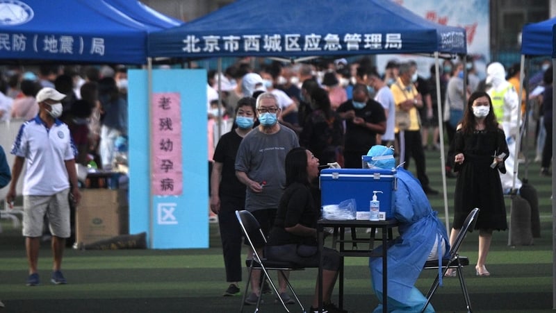 Beijing residents who live near Xinfadi market queue for a coronavirus test