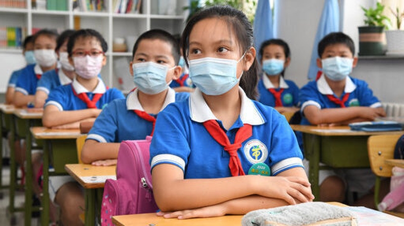 Children wearing masks at a Beijing primary school, pictured days before the latest outbreak