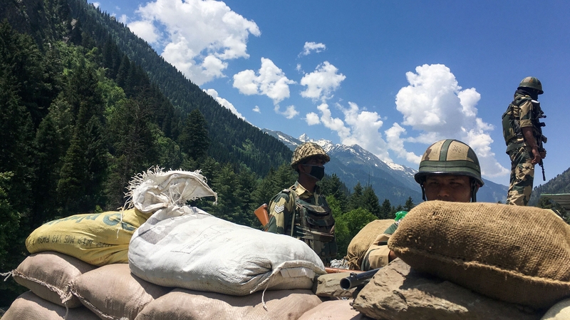 Indian Border Security Force soldiers guard a road leading to the border with China