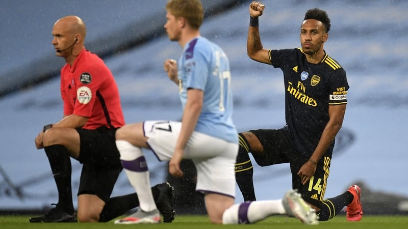 Arsenal's Pierre-Emerick Aubameyang (R) gestures as players and officials take a knee in support of the Black Lives Matter movement at the Etihad Stadium