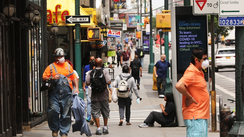 People walk through Manhattan as the city prepares to enter stage 2 of reopening on Monday