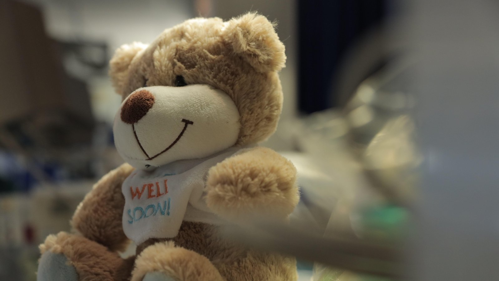 A 'Get Well Soon' teddy sits by a patient's bed in ICU