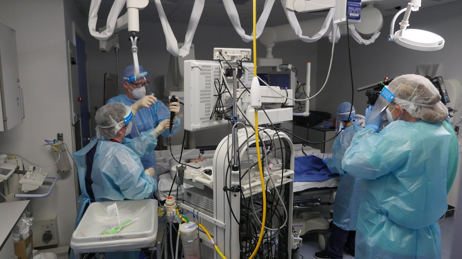 Staff carry out a procedure wearing full personal protective equipment