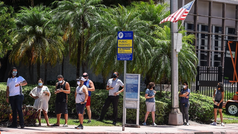 People wait for their testing at a 'walk-in' and 'drive-through' coronavirus testing site in Miami Beach, Florida