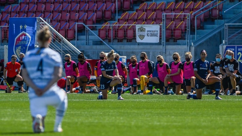 Players from the North Carolina Courage and Portland Thorns FC kneel before their Challenge Cup game