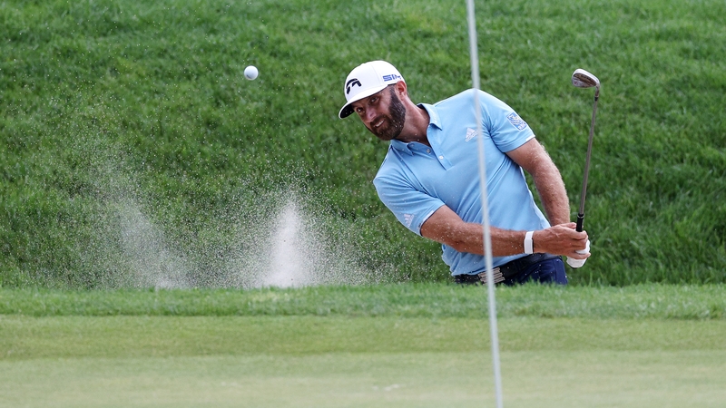 Dustin Johnson plays a bunker shot on the 16th