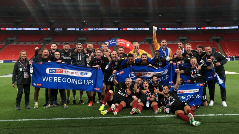Northampton Town players and staff celebrate their promotion to League One