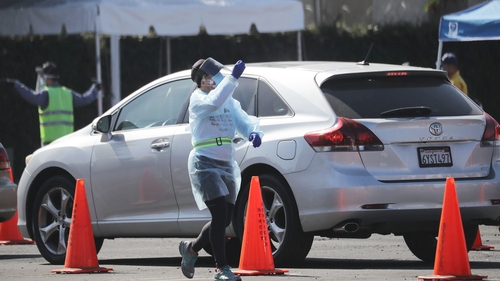 A health worker signals the next in line at a drive-thru Covid-19 test centre in Los Angeles