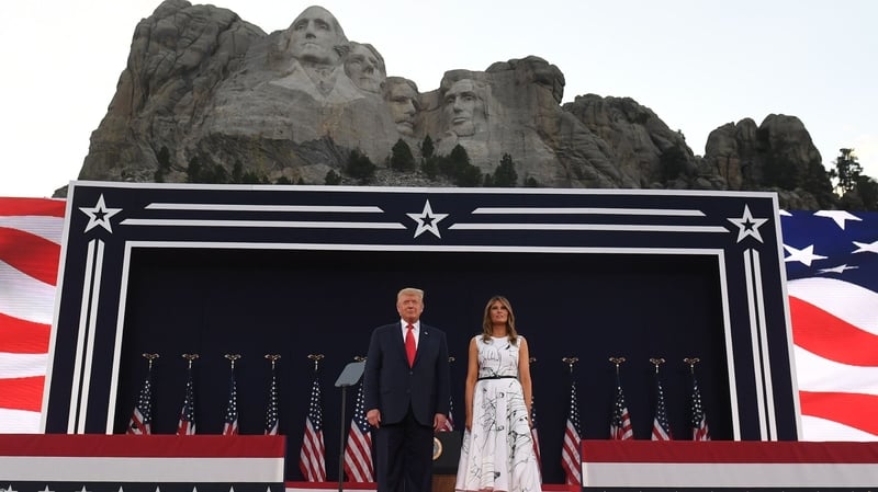 Donald and Melania Trump pose in front of the stage at Mount Rushmore