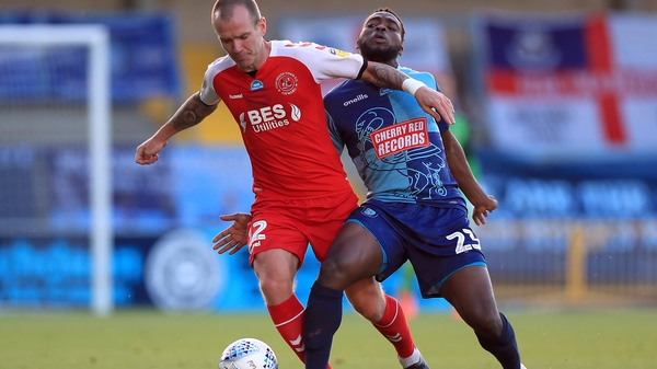 Fleetwood Town's Glenn Whelan (L) holds off Wycombe goalscorer Fred Onyedinma