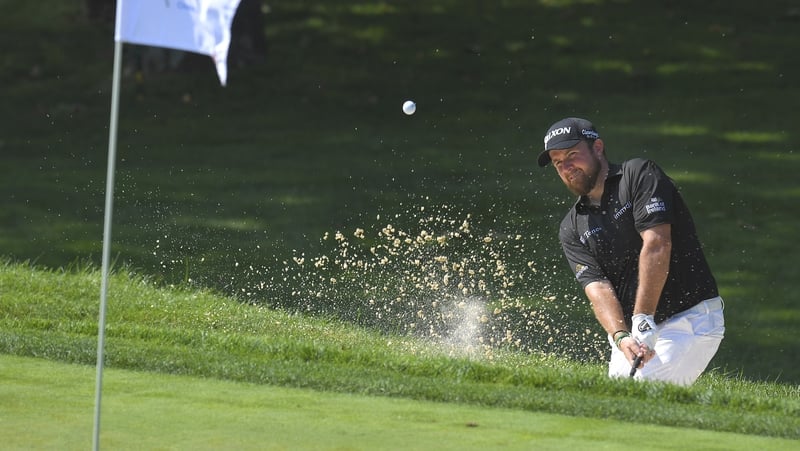 Shane Lowry plays a bunker shot on the fourth hole