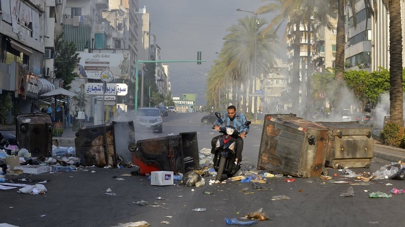 A motorcyclist rides through a blockade in Beirut during a demonstration against the economic conditions