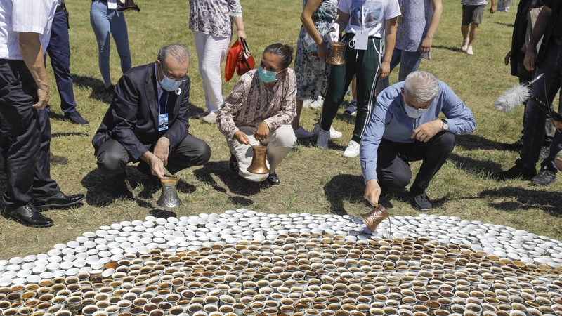 Volunteers installing the sea of ceramic cups in a meadow next to the Srebrenica memorial centre